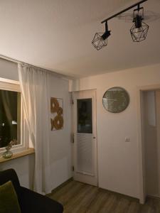 a living room with a clock and a window at Naturnest Berzbuir in Düren - Eifel