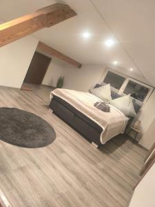 a bedroom with a large bed and a wooden floor at Naturnest Berzbuir in Düren - Eifel