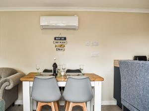 a dining room table with two white chairs at The Stables in Edmondsham