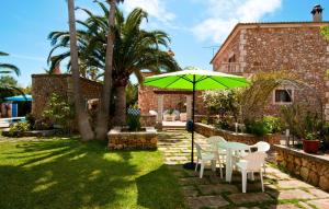 a patio with a table and chairs and an umbrella at Can Lopez Vara in Campos