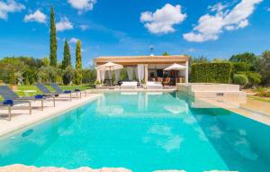 a swimming pool with chairs and a gazebo at Golf Marina in Pollença