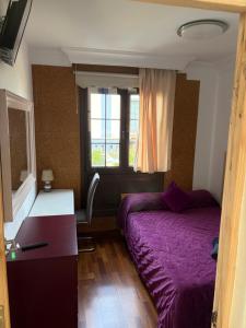 a bedroom with a purple bed and a desk and a window at casa cairasco in Las Lagunas
