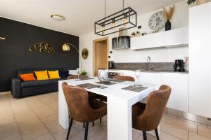 a kitchen and living room with a white table and chairs at IseoLakeRental - Panorama House in Parzanica