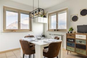 a dining room with a white table and chairs at IseoLakeRental - Panorama House in Parzanica