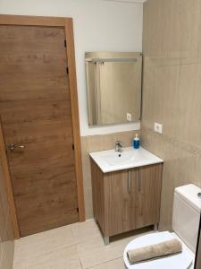 a bathroom with a sink and a toilet and a door at casa cairasco in Las Lagunas