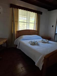 a bedroom with a bed with two towels on it at Coco Beach House in Coco