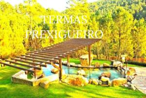 a bridge over a pool with rocks in a yard at A Casa do Aloumiño da Auga Mondariz VT-PO-00148 y SPA Prexigueiro Obsequio entrada por persona a circuito termal in San Félix