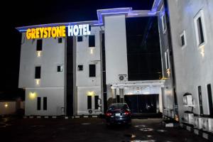 a car parked in front of a building at night at Greystone Hotel in Asaba
