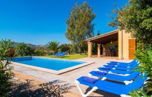 a pool with lounge chairs next to a house at Can Bernat in Cala Mendia