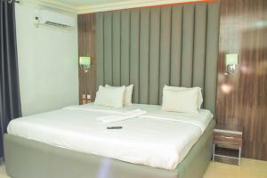 a white bed with a book on top of it at Greystone Hotel in Asaba