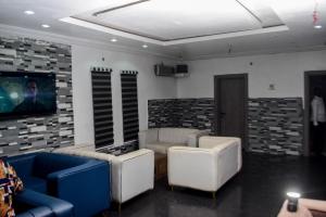 a living room with couches and a flat screen tv at Greystone Hotel in Asaba