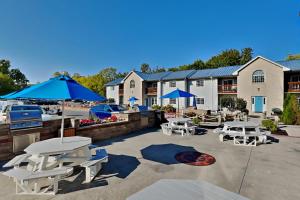 a patio with tables and chairs and blue umbrellas at Put-in-Bay Poolview Condo #6 in Put-in-Bay
