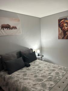 a bedroom with a bed and a painting on the wall at 51 Lazarett Loft & Car Rental in Windhoek