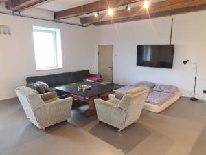 a living room with a couch and a table and chairs at Loft zum alten Kraftwerk in Herzogenburg
