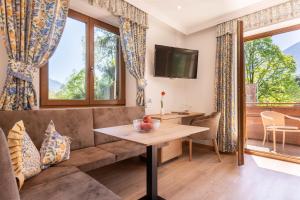 a living room with a couch and a table at Hotel Sittnerhof in Merano