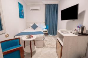 a hotel room with a bed and a tv at Sunshine Pyramids& Grand Museum View in Cairo +17 photos