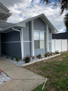 a house with a white fence in front of it at Ortona's Best Kept Secret Three-Two Spacious Home in Orlando
