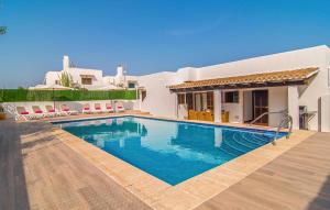 a villa with a swimming pool in front of a house at Murta 26 in Sa Coma