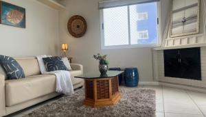 a living room with a couch and a fireplace at Cobertura Duplex a Beira-Mar de Capão da Canoa in Capão da Canoa