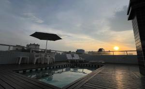 a patio with an umbrella and chairs and a pool at Cobertura Duplex a Beira-Mar de Capão da Canoa in Capão da Canoa +9 photos