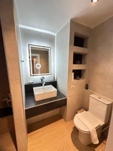 a bathroom with a sink and a toilet at Agali Luxury Home in Khamilón +19 photos