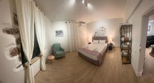 a bedroom with a bed and a chair and a television at Agali Luxury Home in Khamilón