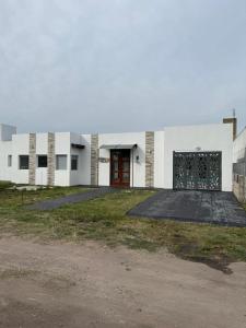 a large white building with a red door at Casa Rincon caleta in Mar de Cobo