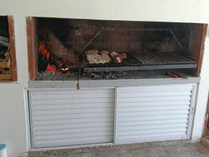 a grill with two garage doors in front of a fireplace at Casa Rincon caleta in Mar de Cobo