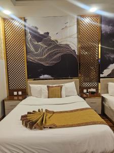 a bedroom with a large bed with a blanket on it at Ambassador Suites in Dargai +55 photos
