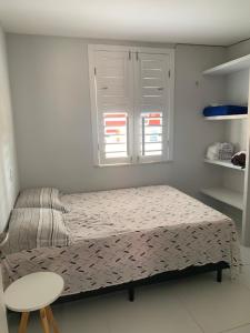a small bedroom with a bed and a window at Apartamento térreo no Morro Branco Marina II in Beberibe +20 photos