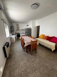 a living room with a table and a bed at Departamentos Valquiria in Monte Hermoso
