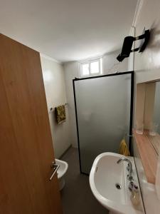 a bathroom with a toilet and a sink and a door at Departamentos Valquiria in Monte Hermoso