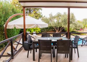 a patio with a table and chairs and an umbrella at Villa Cyprium in Kyrenia
