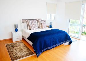 a bedroom with a bed with a blue blanket on it at Villa Cyprium in Kyrenia