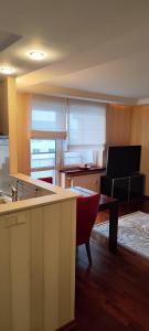 a room with a kitchen with a table and a couch at Apartament Rycerska LUX in Łomża