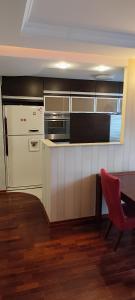 a kitchen with a red chair and a table at Apartament Rycerska LUX in Łomża