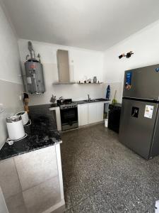 a small kitchen with a refrigerator and a stove at Departamentos Valquiria in Monte Hermoso +5 photos