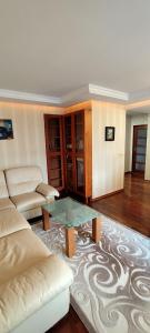 a living room with a couch and a table at Apartament Rycerska LUX in Łomża