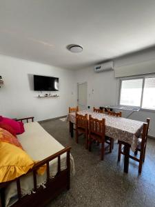a room with two beds and a table and chairs at Departamentos Valquiria in Monte Hermoso