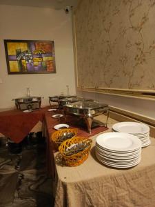 a buffet with plates and bowls on a table at Ambassador Suites in Dargai