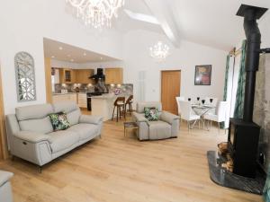 a living room with two couches and a kitchen at The Barn in Redditch