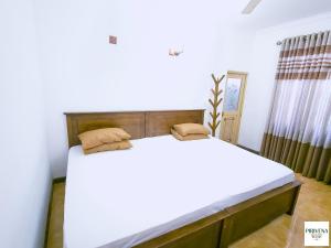 a bedroom with a large bed with white sheets at Second Home Resort- Homestay AC Room with Attached Bathroom and WiFi in Boralesgamuwa