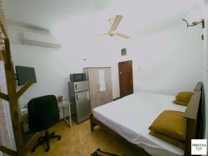 a bedroom with a white bed and a desk at Second Home Resort- Homestay AC Room with Attached Bathroom and WiFi in Boralesgamuwa