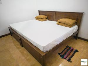 a large bed with white sheets and two pillows at Second Home Resort- Homestay AC Room with Attached Bathroom and WiFi in Boralesgamuwa
