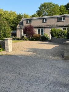 a house with a gravel driveway in front of it at Woodlands Banff in Banff