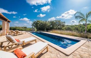 an outdoor swimming pool with chaise lounge chairs next to a villa at La Fuente De Montuiri in Montuiri