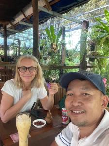 a man and a woman sitting at a table with a drink at Authentic Joe homestay in Siem Reap