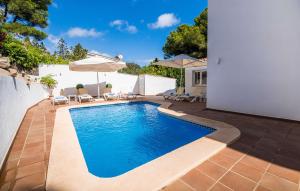 a swimming pool in a yard with chairs and umbrellas at Mar Bella Nou in Font de Sa Cala