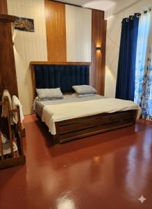 a bedroom with a bed with a blue headboard at HA Homes in Matale