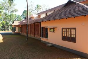 a house with a courtyard in front of it at Vaigayi Ayurveda and Yoga Resort in Kodanad
